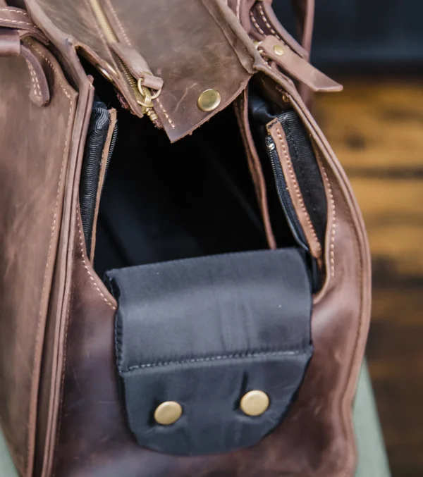 Designed for both fashion and functionality, this high-end leather pet carrier allows you to travel in style with your furry friend. This all-in-one pet travel bag provides a safe, cosy, and stylish way to take your dog or cat with you, whether you're going to the vet, going on a weekend trip, or just going for a stroll. This dog tote bag carrier is made of premium leather and has a roomy, airy interior, sturdy handles, and a plush lining for your pet's comfort. While the multipurpose pockets provide room for snacks, leashes, and necessities, the structural design maintains its shape. It's ideal for small to medium-sized pets and blends in perfectly with your everyday routine. You may use it as a dog walking bag, cat carrier, or easy travel bag for dogs.